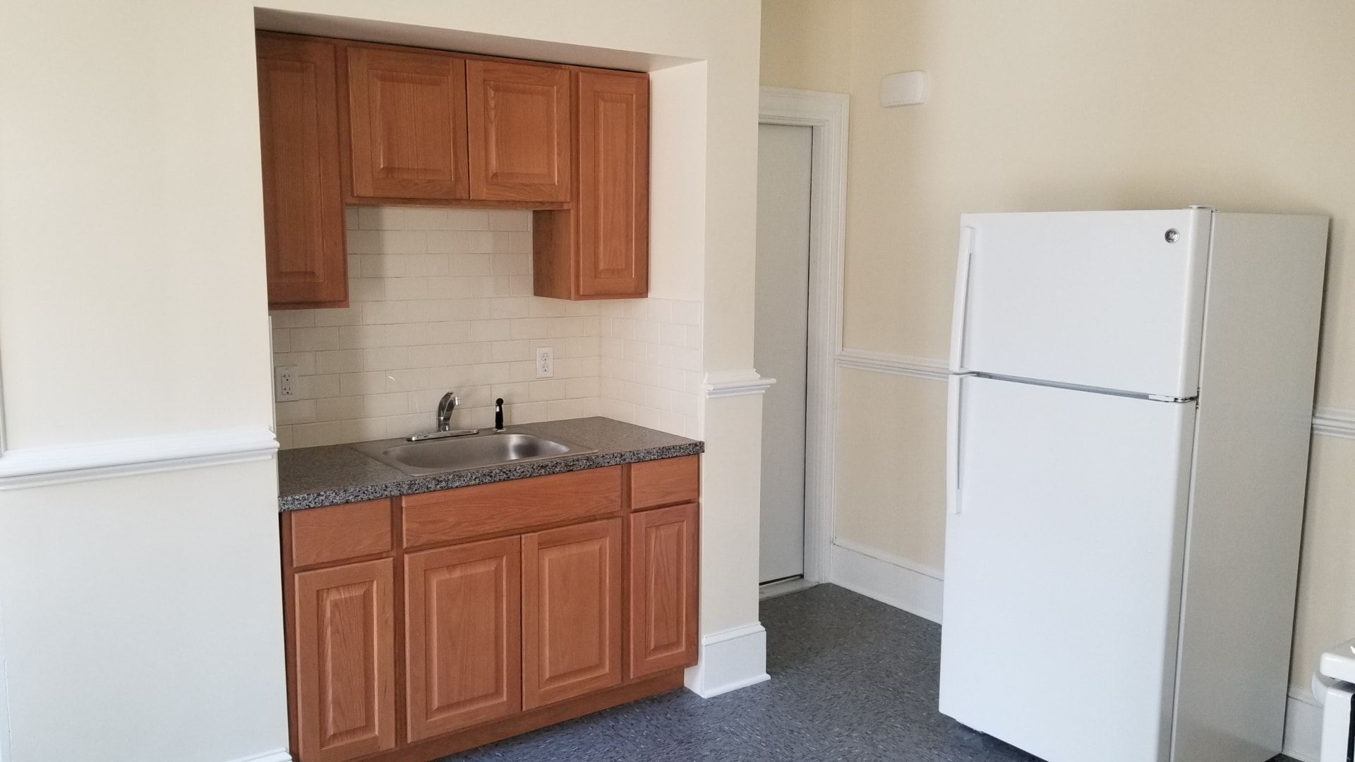 New kitchen with wood cabinets, granite counter, subway tile and appliances