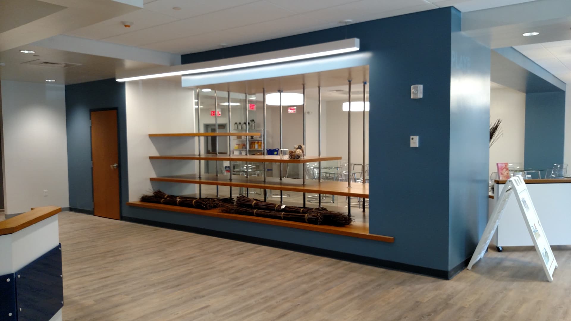 Finished player area with blue accent wall, open shelving and glass walled cafe