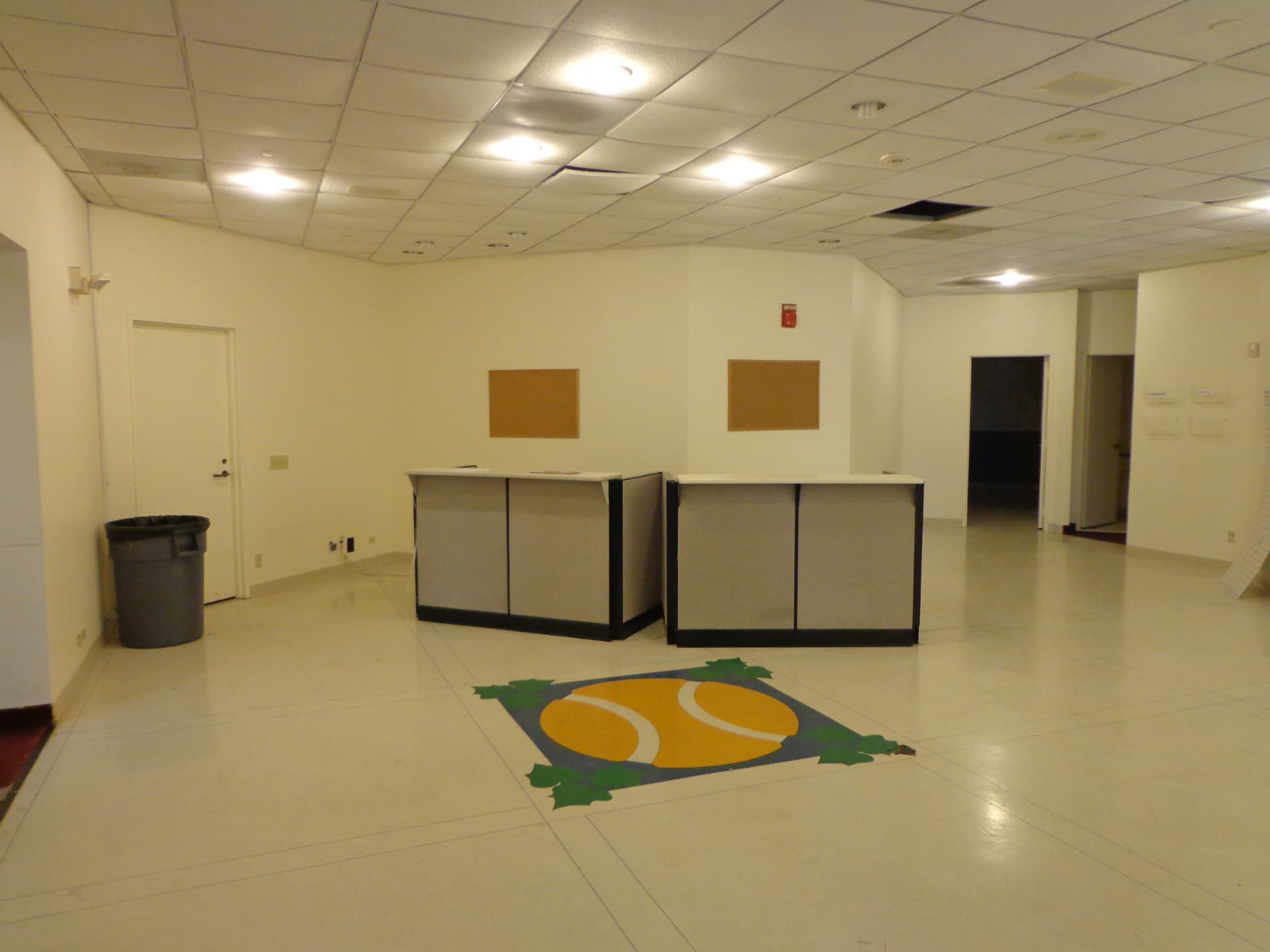 Old player services area with temporary desks and tile floor before renovation